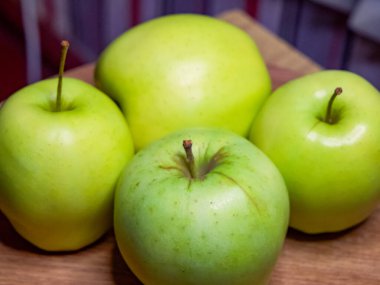 Düzgün sıralanmış parlak yeşil elmalar, bir pazar ortamında organik ürünlere odaklanmayı ima eder.