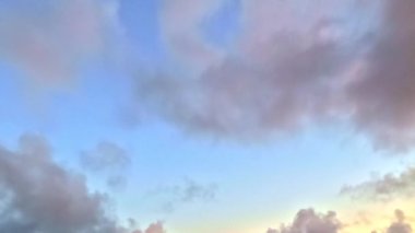 Günbatımı gökyüzü, bulutlar, mavi ve turuncu renkler, barışçıl atmosfer.