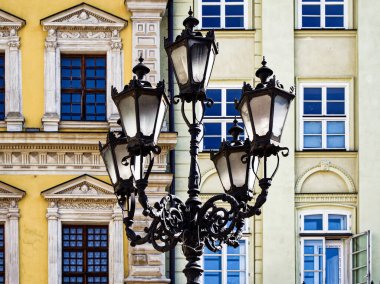 Vintage Lamppost: Tarihi ve mimari zarafetin sergilendiği bir Avrupa binası önünde süslü bir sokak lambası.