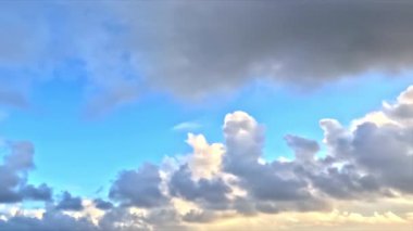 Bulutlu, güneşli ve mavi tonlu bir gökyüzü; huzur verici, rahatlatıcı görseller için kullanılır..