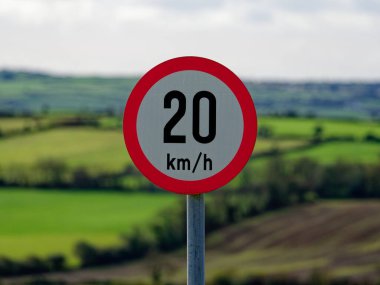 A circular traffic sign displaying 20 km/h suggests a controlled speed zone, possibly near a pedestrian space or delicate road conditions clipart