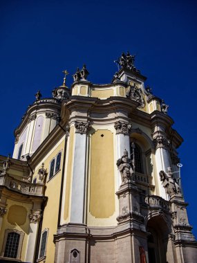 Ayrıntılı kilise girişi: Heykel ve armalarla süslenmiş, kentsel bir ortamda Avrupa dini sanatının sergilendiği ayrıntılı bir kilise girişi. Lviv şehrindeki St. George Katedrali
