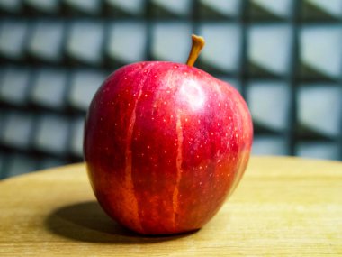 Olgun elma damlacıkları, yumuşak gri arka plan tazeliği vurguluyor.