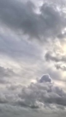Gökyüzü bulutlu, güneş ışınları parlıyor, gri bulutlar hakim..