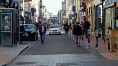 Cork, İrlanda, 30 Eylül 2022. Günlük hayatta bir ritim duygusu. Şehrin kaldırım taşı sokağında yürüyen bir adam. Cork sakinleri bir sabah şehrin sokaklarında yürüyorlar..