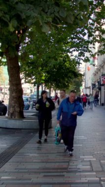 Cork, İrlanda, 30 Eylül 2022. Cork sakinleri bir sonbahar sabahı şehrin sokaklarında yürüyorlar. İrlanda 'da şehir hayatı. Sokaktaki insanlar. Şehir hayatının uğultusu.