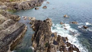 Dalgalar çekildiğinde kayalık sahil kenarındaki berrak sular sahilin doğal güzelliğini gözler önüne seriyor..