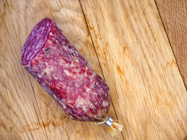 stock image Dried, cured meat on wood, perfect for a charcuterie board or gourmet meal.