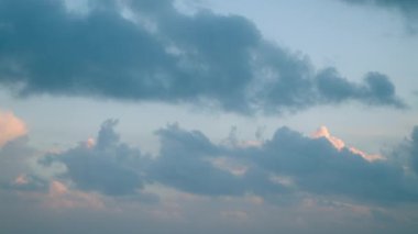 Gökyüzü ağırlıklı olarak açık mavi renktedir, bazı beyaz bulutlarla. Büyük, koyu gri bir bulut.