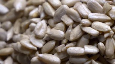 Ayçiçeği tohumlarının oval şekillerini ve açık kahverengi renklerini gösteren yakın plan bir video..