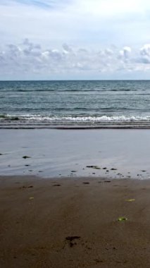 Su açık mavi-yeşil bir renktir, gökyüzünden gelen ışığı yansıtır. Ufuk ince bir çizgidir, görünür bir kara parçası yoktur. Bulutlar kabarık ve beyaz.