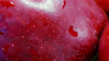 İki kırmızı elmanın yüzeyinin detaylı bir görüntüsü. Yüzeyde ince bir parıltı ve küçük beyaz lekeler ile deri dokudur..