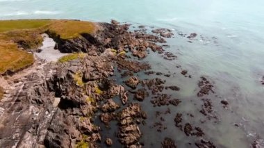 Kıyı kayalıkları dalgaların çekildiği kayalık arazi ve gelgit havuzlarını gözler önüne seriyor.