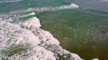 Okyanus yüzeyinin hava perspektifi kırılan dalgaların beyaz köpüğü ile suyun koyu yeşilimsi rengi arasındaki zıtlığı vurgular..