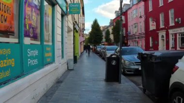 Clonakilty, İrlanda, 1 Ekim 2024. Sokakta park etmiş bir sürü arabayla küçük bir İrlanda kasabasında yürümek. Kişisel POV.