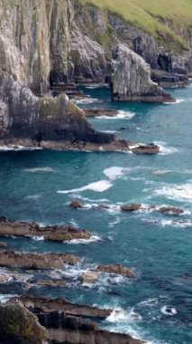 Okyanus dalgaları karanlık, düzensiz kıyı kayaları ve kayalıklarda kırılır. Uçurumlarda deniz kuşları görülebilir..
