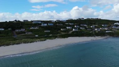 Güneşli bir günde sakin bir sahil ve yamaç manzaralı evler..