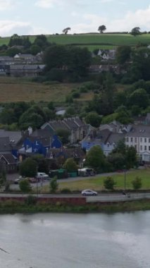 Video, evler, yollar, su ve çevre tepeleri içeren bir kasabanın yerleşim planını gösteriyor. Video yüksek bir yerden çekilmiş..