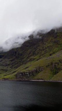 Yükselen sisli tepeler arasında uzanan huzurlu bir gölün güzelliğine tanık olun. Atmosfer sakin ve sakin. Doğanın kucağına mükemmel bir kaçış sağlıyor..