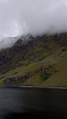 Uzak bir yerde, sisli dağlarla çevrili sakin bir göl manzarasını keşfedin..