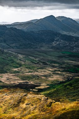 Stunning view of verdant valleys and rugged mountains in a remote landscape during overcast weather. clipart