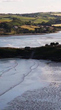 Sahil manzarası sakin sahil manzarası, yuvarlanan tepeler ve gün batımında sakin sular..