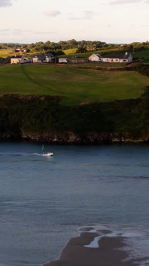 Sakin sular ve yeşil tepeler sakin bir sahil köyünde güzel bir manzara yaratır..