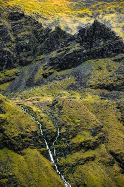 İrlanda 'daki Carrauntoohil Yolu, dramatik dağ zirvelerinin altındaki yemyeşil tepeler ve akarsulardan oluşan nefes kesici bir manzara..