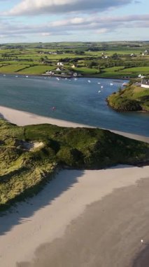 Yuvarlanan tepeler ve kumlu kıyılarla çevrili bir nehir kıyısının huzurlu güzelliğine bakın. Doğanın ahengi altın saat boyunca sergilenmektedir..