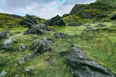 İrlanda 'daki Carrauntoohil geçidi, yemyeşil ve engebeli kayalarla çevrili. İzler, dağlık arazinin nefes kesici manzaralarını sunuyor. Macerayı davet ediyor..
