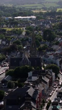 Kuş bakışı bir kasabanın yerleşim yerini gösteriyor, yüksek kulesi olan büyük bir taş kilise göze çarpıyor..