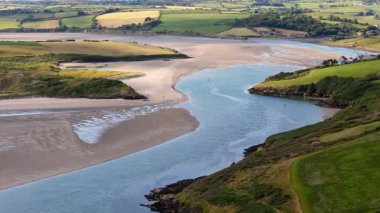 Sarmal nehirlerin, yemyeşil tepelerin ve huzurlu kumlu plajların bulunduğu İrlanda 'nın nefes kesici manzarasını keşfedin. Bu manzarada doğanın güzelliğini tecrübe et..