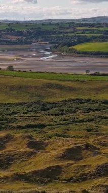 İrlanda 'nın kırsal kesiminin güzelliğini, akan tepeler ve akan nehirlerin gün batımının değişen ışığı tarafından dönüştüğünü hissedin. Yeşillik ve huzurlu manzaralar manzarayı doldurur..