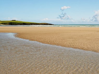 Idyllic plaj cenneti. Altın kumlar parlak bir gökyüzünün altında ufka kadar uzanıyor. Huzurlu sahne rahatlama ve kaçma hissi uyandırıyor..