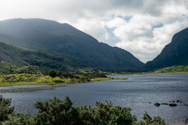 Yuvarlanan tepeler ve vadiler arasında yer alan Kara Göl, İrlanda 'da bulutlu gökyüzü ve su yüzeyiyle sakin bir manzara yaratıyor..