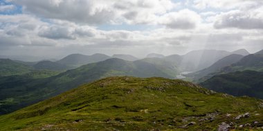 BlackValley 'in yuvarlanan yeşil tepeleri uzak dağların arka planına doğru uzanıyor. Yumuşak, dağınık ışık manzaraya, keşfi davet eden sakin ve sakin bir atmosfer verir..