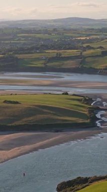 İrlanda kırsalının güzel manzarası dolambaçlı nehir ve gün batımında yemyeşil tarlalar.