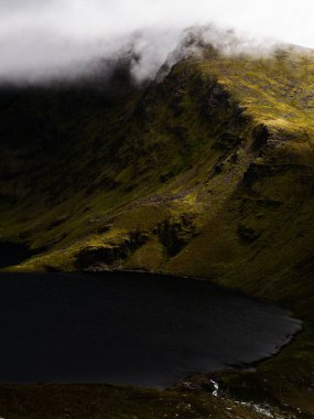 Sisin içindeki yemyeşil bir dağın nefes kesici görüntüsü, alttaki ıssız tarn 'ın mürekkep gibi sularına yansıyan heybetli şekli..