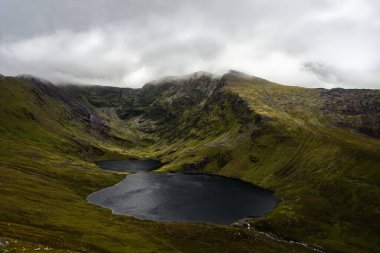 Coomloughra Lough İrlanda 'nın engebeli güzelliğinin ve huzurlu manzarasının nefes kesici bir yansımasını sunuyor..