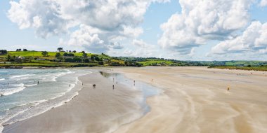 West Cork, 25 Haziran 2023. Sahil manzarası, insanların rahatladığını ve havanın tadını çıkardığını gösteriyor. Huzurlu atmosfer, uzaktaki yuvarlanan tepelerle güçlenir..