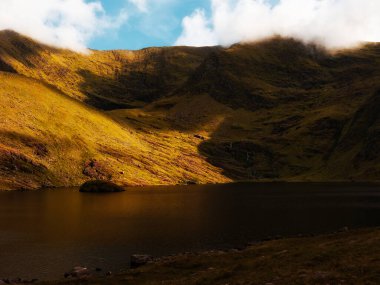 Lough Callee, tepeleri yansıtan durgun sularla çarpıcı bir manzara sunuyor. Çevresindeki arazi canlı renkler ve gölgeler sergiliyor ve İrlanda doğasında pitoresk bir manzara yaratıyor..