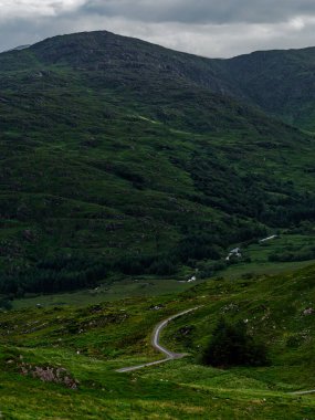 Sarmal yollar, İrlanda, BlackValley 'in canlı yeşil tepelerinden geçiyor. Manzaralı güzellik, sakin manzarayı gözler önüne seriyor. Doğanın harikalarını keşfetmeye ve takdir etmeye davet ediyor..
