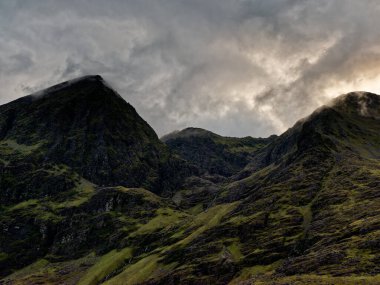 İrlanda 'daki Majestic Carrauntoohil dramatik bulut oluşumlarıyla alacakaranlıkta.