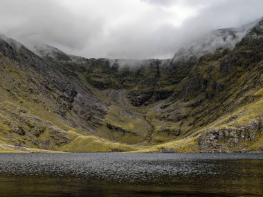 Puslu dağ gölü engebeli bir vadiye kurulmuş. Doğanın gücü ve sessiz güzelliğinin sakin ama dramatik bir sahnesi..