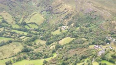 İrlanda 'nın kırsal kesiminin nefes kesici güzelliğini tecrübe edin, dalgalı tepeler, canlı yeşillikler, ve açık güneşli bir günde dağınık çiftlik evleri.