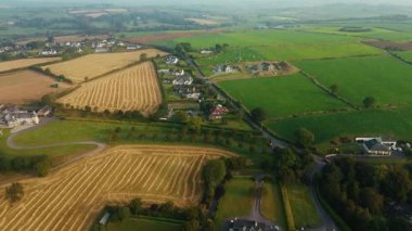 Clonakilty, İrlanda 'nın hava manzarası, güzel bir sabahta evleri, tarlaları ve dolambaçlı yolları gösteriyor..