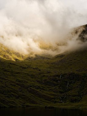 Yeşil tepeler Lough Callee ile buluşur ve gökyüzü bulutlarla kaplanır, İrlanda 'da büyülü bir his verir.