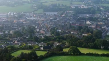 Clonakilty, İrlanda, 7 Eylül 2024. İrlanda, Clonakilty 'de sabahın erken saatlerinde kilisenin, yeşil otlakların ve renkli evlerin manzarasını gözler önüne seriyor..