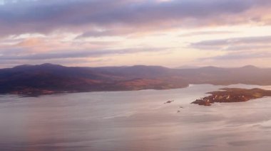 İlçede hava kararıyor. Dağlar kıyılarla birleşiyor, gözün alabildiğince uzanan sular bulutlu bir gökyüzünün altında. Işık sahneyi biraz daha parlak gösteriyor..