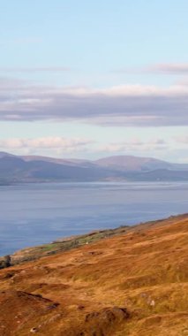 Bu, sabahın erken saatlerinde dağlık arazide çekilmiş bir tepe manzarası. Gökyüzü yumuşak bulutlarla kaplı..